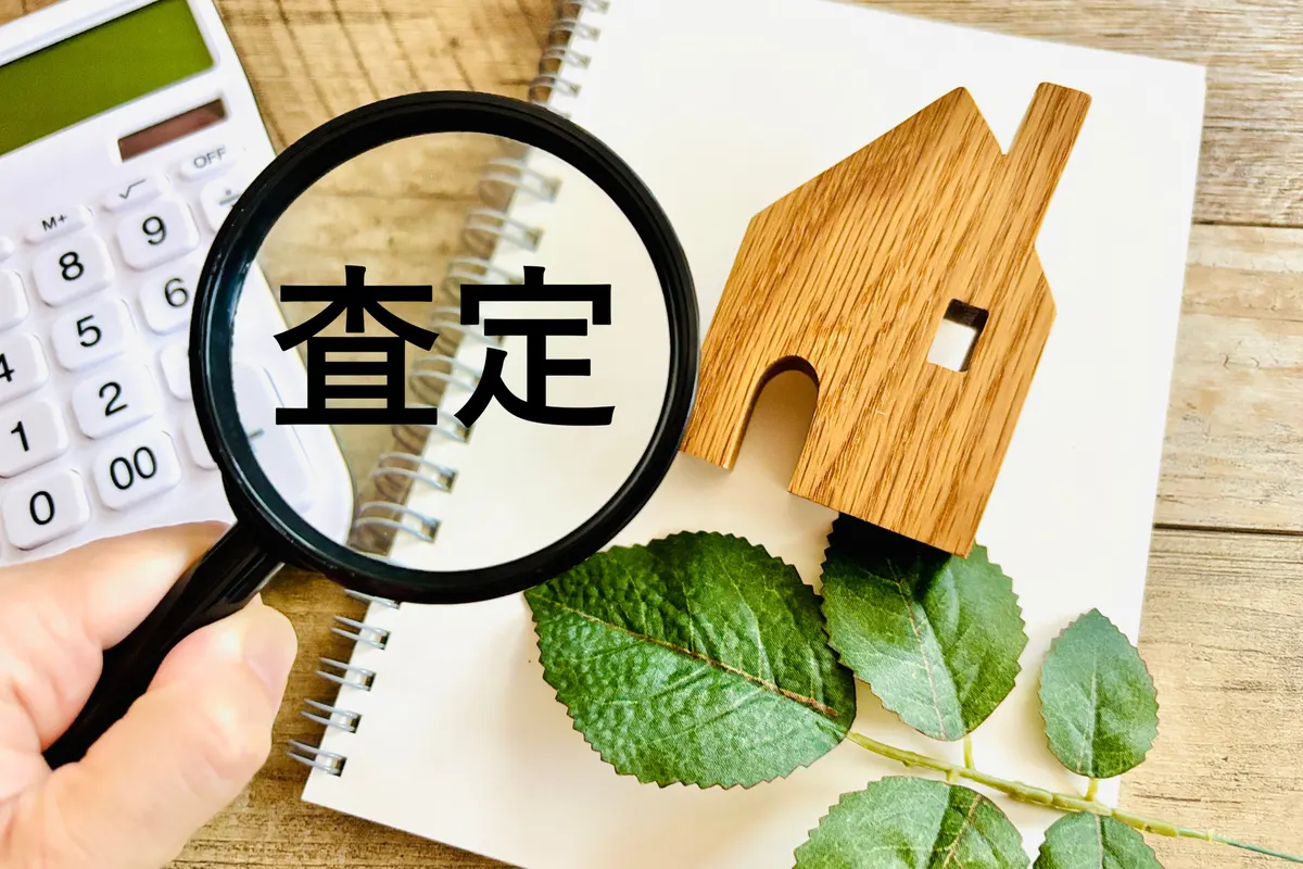 虫眼鏡で査定の文字を見ている