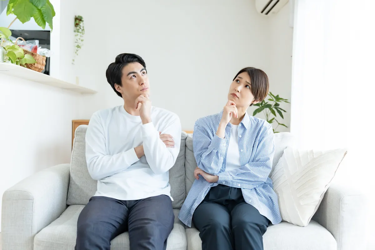 ソファで考えごとをするご夫婦