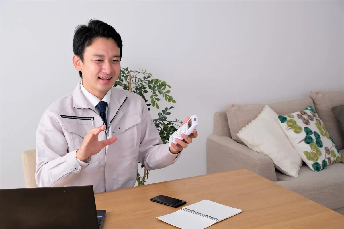 電卓を手にお見積りを説明するスタッフ