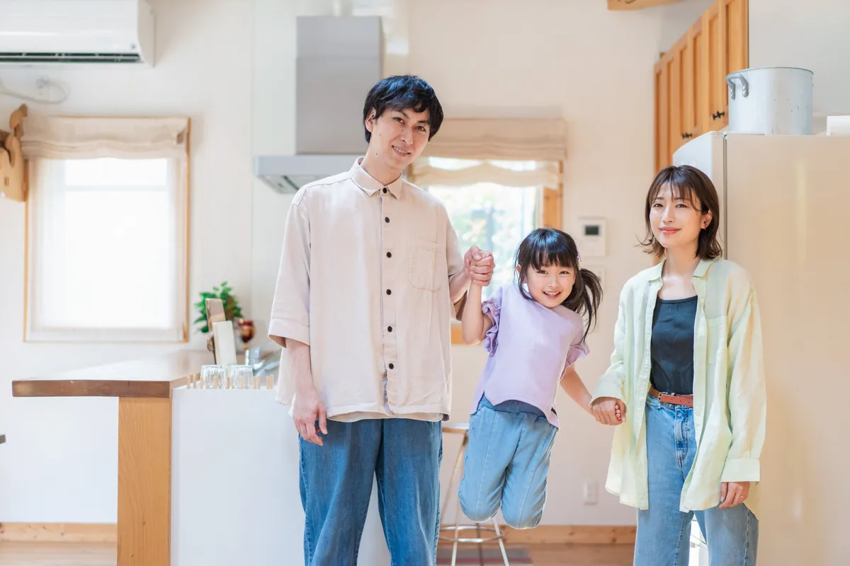 新しいおうちのキッチンで、お子様と手をつないで喜ぶご家族