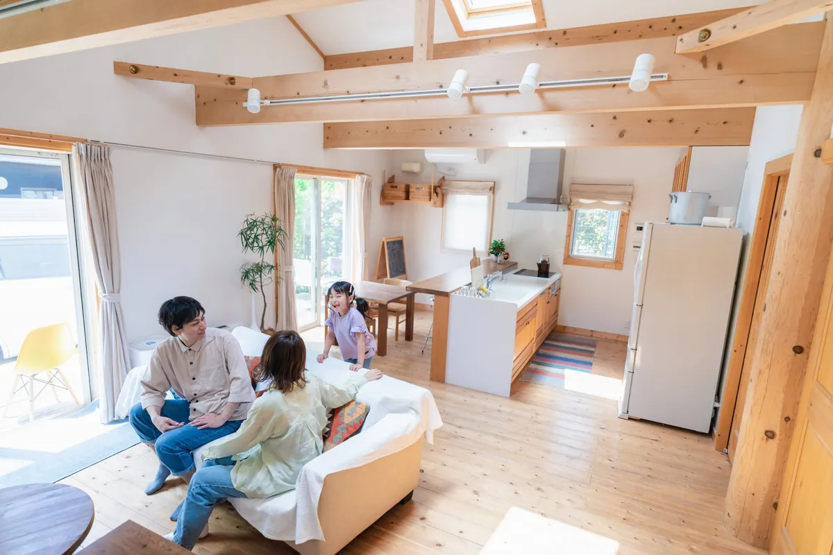 梁を見せた吹き抜けのリビングでくつろぐご家族