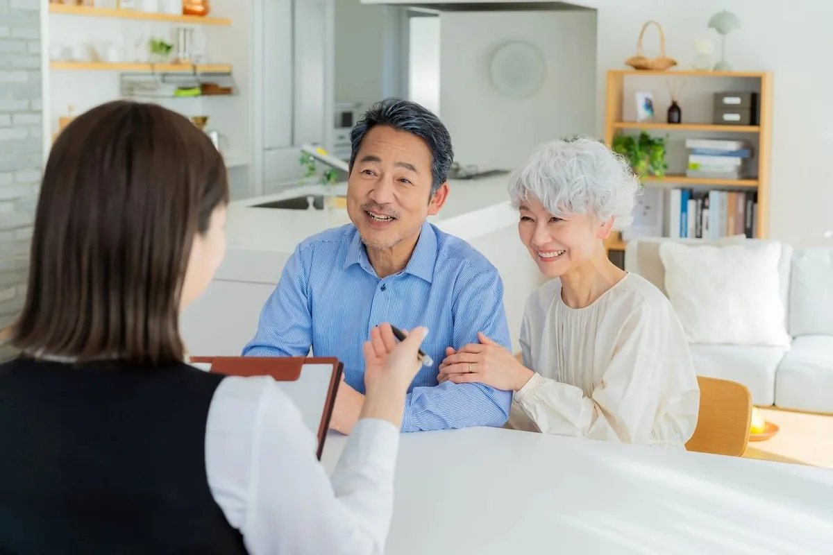 女性スタッフの説明を笑顔で聞く年配のご夫婦
