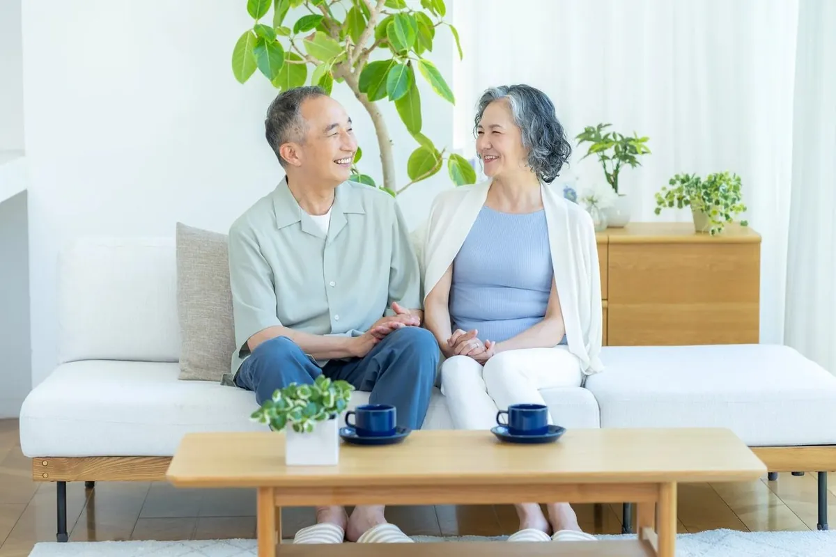 自宅のソファで笑顔の年配のご夫婦