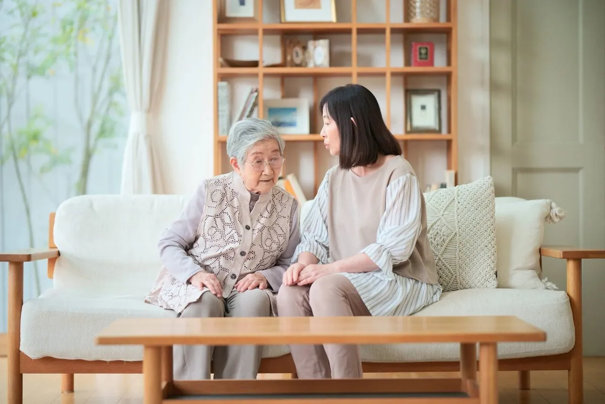 ソファで相談する年配の母と娘